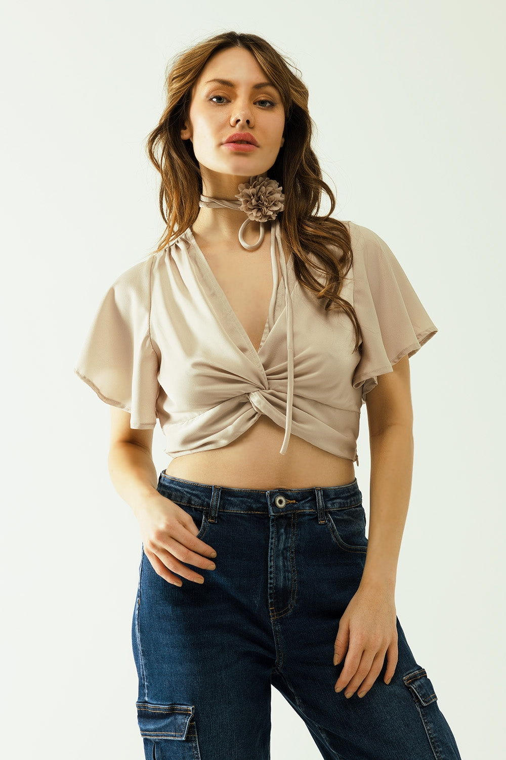 Beige v-neck crop top with short sleeves and a flower detail on the neck | Just Cool Beans — tops | bottoms